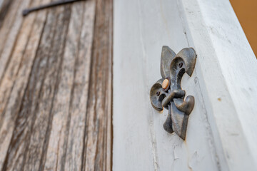 A decorative fleur de lis shaped doorbell in the French Quarter in New Orleans. - obrazy, fototapety, plakaty