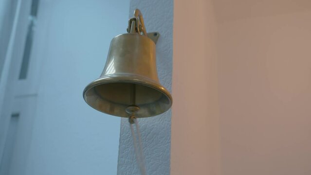 a woman's hand pulls the thread of a bell for a meeting in the office. the ringing of a bell in the room. close-up