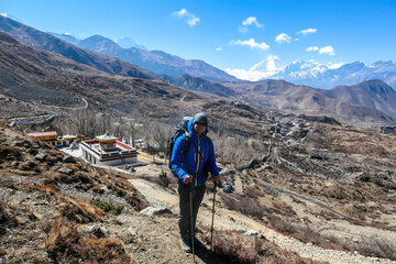 A man hiking through Himalayan valley, located in Mustang region, Annapurna Circuit Trek in Nepal....