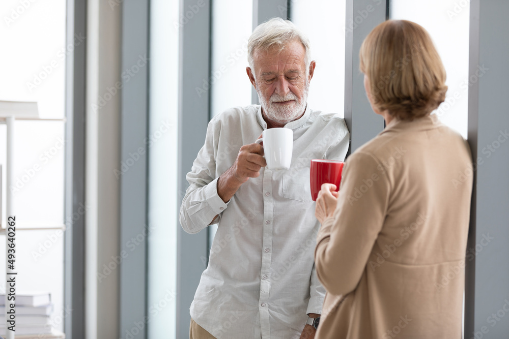 Wall mural senior businessman holding a cup of coffee and talking about work in free time