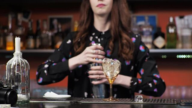 Redhead girl Young adult woman bartender prepares mixes paper airplane cocktail bar Pours ice bells