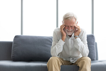 senior elderly man have a headache on a sofa