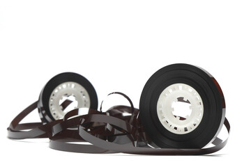 Old cassette with unwound tape. Damaged data medium for old sound recording devices. White background. Pieces of an old vintage cassette tape