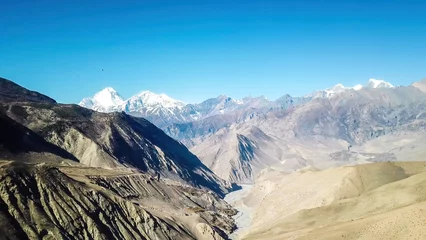 Papier Peint photo Dhaulagiri Une vue panoramique sur le paysage sec de l& 39 Himalaya. Situé dans la région du Mustang, Annapurna Circuit Trek au Népal. À l& 39 arrière, il y a les sommets enneigés du Dhaulagiri I. Des pentes arides et abruptes. Condition sévère.