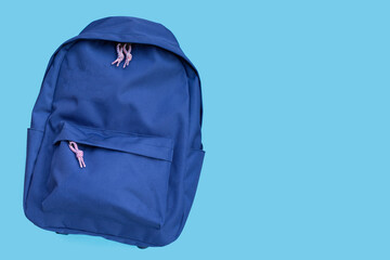 Blue backpack on blue background. Copy space
