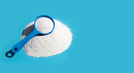 Detergent powder with measuring spoon for clothes washing. Laundry concept.