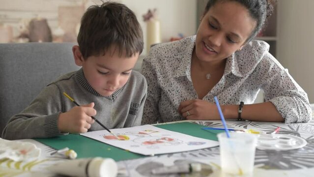 metis mother doing painting with her son	