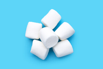 Delicious white marshmallows on blue background.
