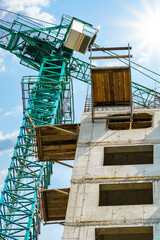 construction of a multi-storey residential building - concrete frame, building materials and construction crane