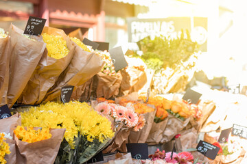 Flower business. Flowers are white in kraft paper standing on the counter. German words: summer chrysanthemum, Words in German: summer chrysanthemum, paradise daffodils, freshness 7 days guaranteed