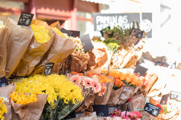 Flower business. Flowers are white in kraft paper standing on the counter.