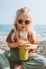 Toddler girl drinking organic smoothie reusable glass bottle child vegan food healthy lifestyle...