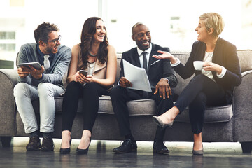 They couldnt be happier about working together. Shot of a group of businesspeople brainstorming together in an office.
