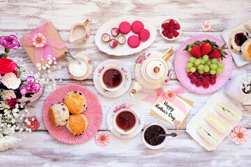 Mother's Day tea table scene against a white wood background. Greeting card, flowers, vintage tea...