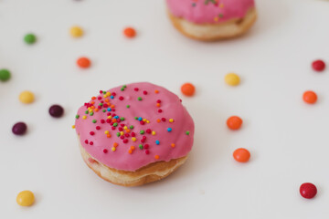 holiday, birthday party composition with colorful pink glazed donuts on white 