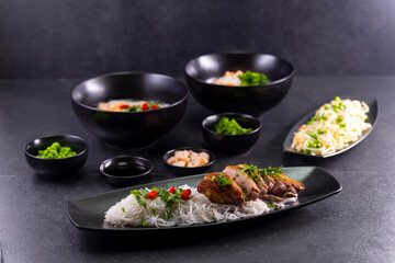 Various dishes of Asian cuisine with different types noodles and rice with shrimp, duck, vegetables and black sesame