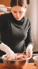 beautiful woman preparing more meat for hamburgers