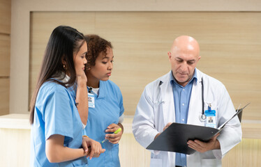 A medical professor gives advice on patient examinations to medical students practicing