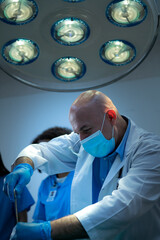 A medical professor is teaching surgery to medical students working