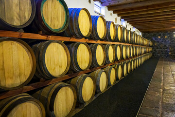 Stacked wooden barrels in a wine cellar
