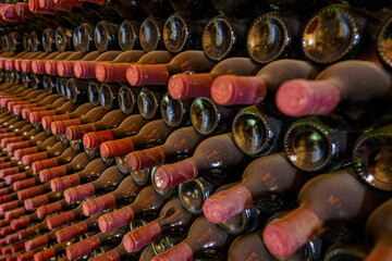 Red wrapped wine bottles stacked in a cellar