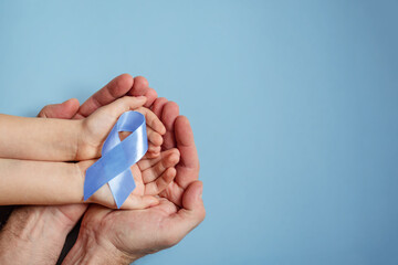 National Child Abuse Prevention Month Hand in hand dad protects daughter and holds a blue ribbon
