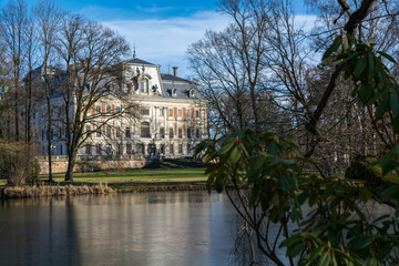 Pszczyna Castle near small lake in park, Pszczyna City in Poland