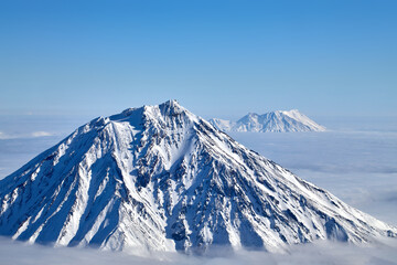 Mountain sunny landscape. Mountain peak over white thick clouds.