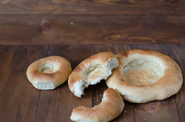 uzbek flatbread white bread is broken into pieces crumbs on a brown background illustration