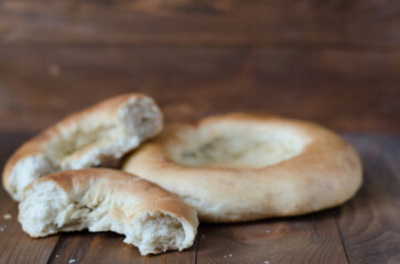 uzbek flatbread white bread is broken into pieces crumbs on a brown background illustration