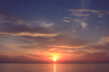 Obraz premium Morning sunrise from the sea in gray clouds