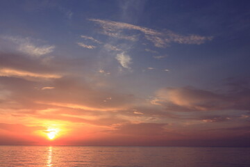 Obraz premium Morning sunrise from the sea in gray clouds
