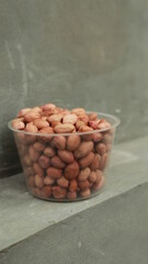 Salted Roasted Peanuts, Peeled raw peanuts are in a plastic cup, Healthy content, Copy space, top view.