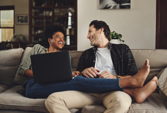 Theres No One Else Id Rather Spend My Day With. Full Length Shot Of A Happy Young Couple Using A Laptop While Relaxing On A Couch Home.