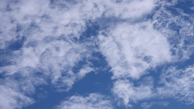 Stratus clouds on a blue sky background. Slow motion. 