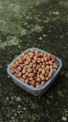 Salted Roasted Peanuts, Peeled raw peanuts are in a plastic cup, Healthy content, Copy space, top view.