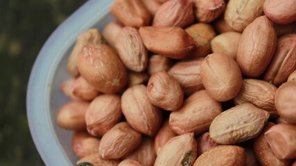 Salted Roasted Peanuts, Peeled raw peanuts are in a plastic cup, Healthy content, Copy space, top view.