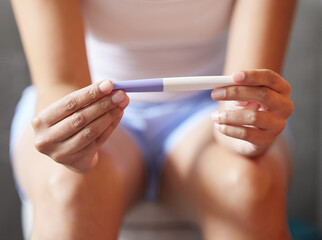 What does it say. Shot of an unrecognizable woman holding a pregnancy test in a bathroom at home.