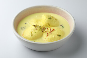 Rasmalai is an Indian dessert sweet with dry fruits and Saffron toppings, served in a bowl . selective focus