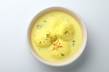 Rasmalai is an Indian dessert sweet with dry fruits and Saffron toppings, served in a bowl ....
