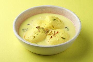 Rasmalai is an Indian dessert sweet with dry fruits and Saffron toppings, served in a bowl ....