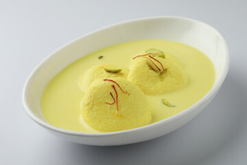 Rasmalai is an Indian dessert sweet with dry fruits and Saffron toppings, served in a bowl . selective focus