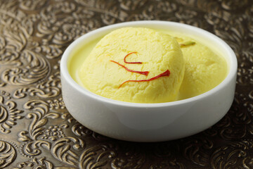 Rasmalai is an Indian dessert sweet with dry fruits and Saffron toppings, served in a bowl . selective focus