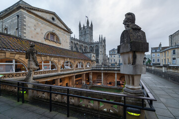 Fototapeta premium City of Bath, UK. Evening sightseeing of restored in Victorian times ancient Roman Baths in the fire light of wall sconces.