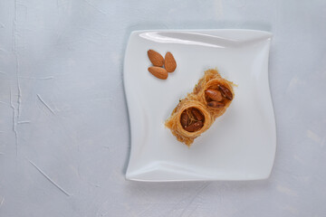 Traditional arabic and turkish sweets pastry dessert kadaif with nuts and dried sweetened.