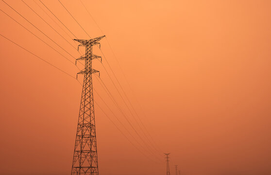 high voltage power lines between the haze of the sahara desert