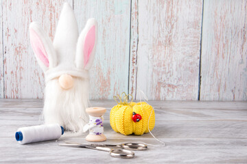 a dwarf with rabbit ears. The workplace of a creative person is threads and yarn