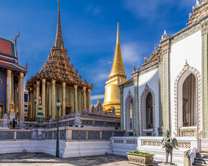 Fototapeta na wymiar Courtyard of ornate Buddhist temples with golden and colorful decorative details, Bangkok, Thailand