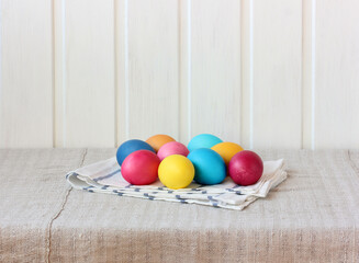 painted Easter eggs on the table on a light wooden background.