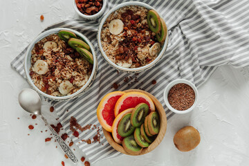 Oatmeal porridge bowl with with kiwi, banana, raisins in blue bowl. Healthy breakfast food, vegetarian breakfast. Top view